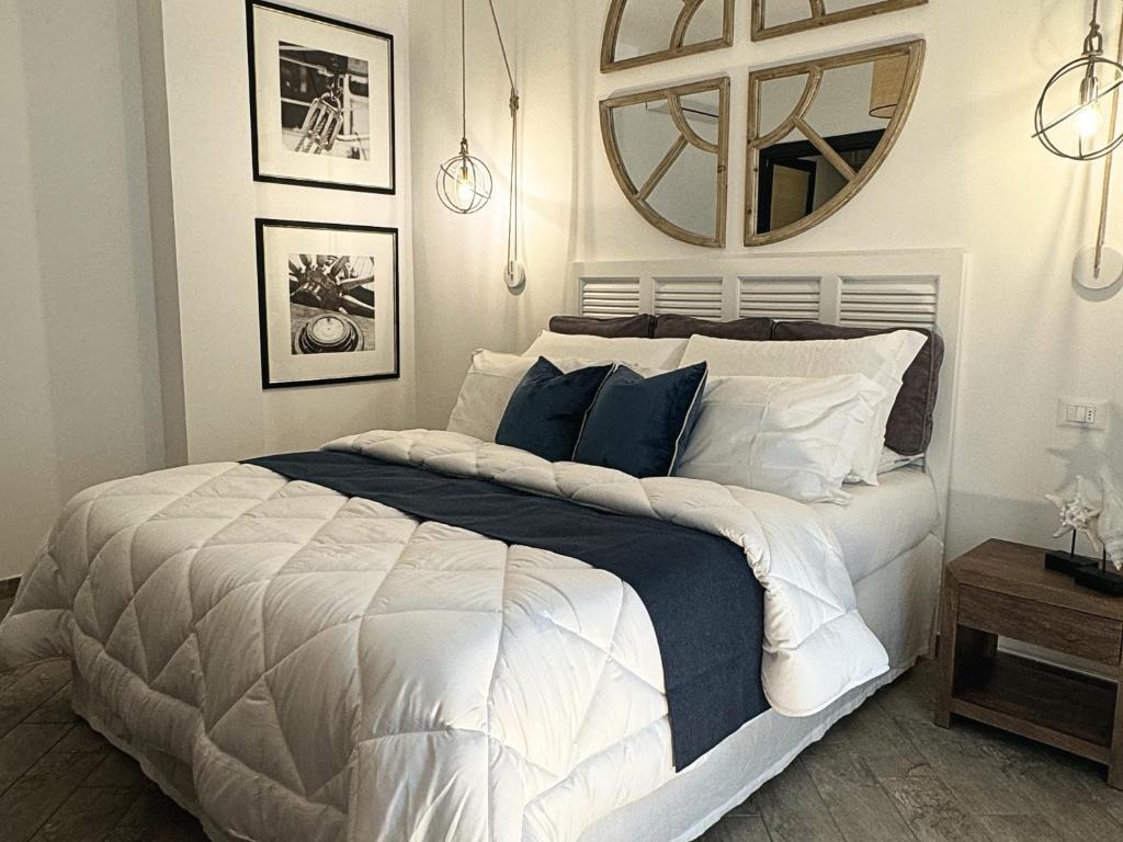 a bedroom with a large bed and a mirror at Libeccio - Villa Marina in Marina di Andora