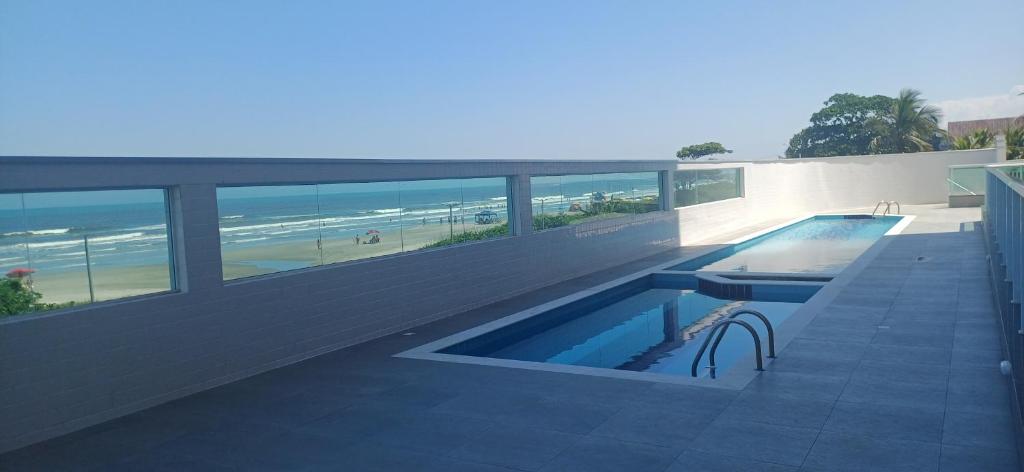 a swimming pool on a building with a view of the beach at Apto 83 in Itanhaém