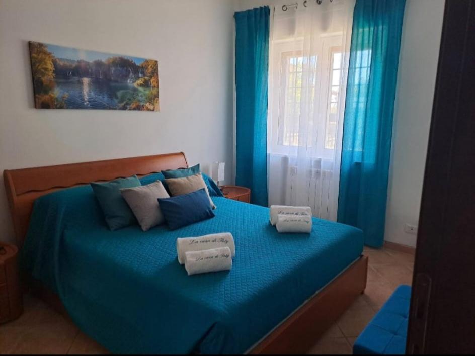 a bedroom with a blue bed with towels on it at La Casa di Taty in Campagnano di Roma