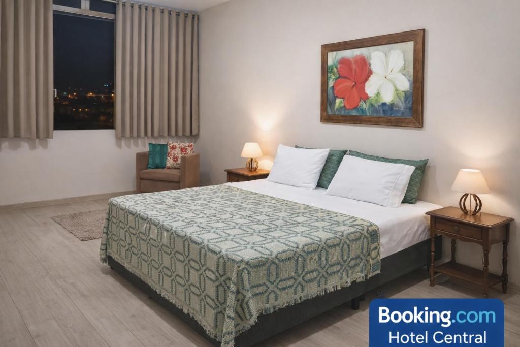 a hotel room with a bed and a painting on the wall at Hotel Central in Amparo