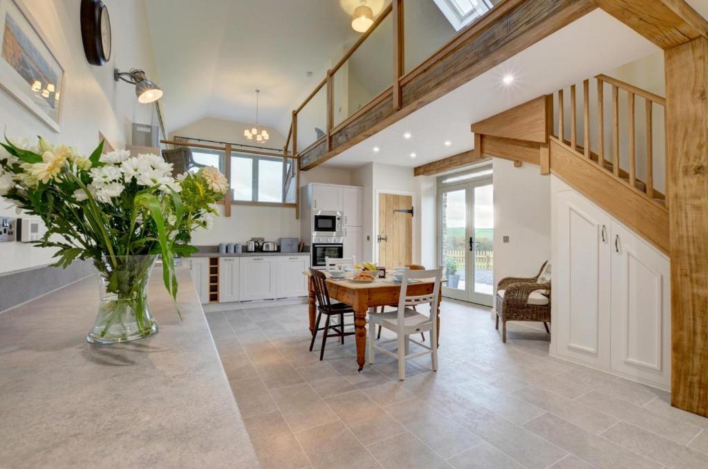 a kitchen and dining room with a table and a vase of flowers at 2 Bed in Bishops Nympton oc-barton in Bishops Nympton