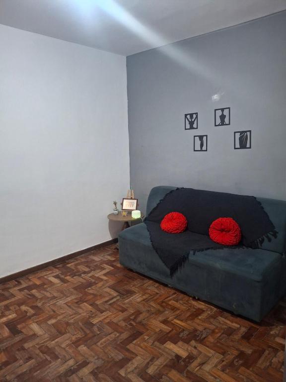 a living room with a blue couch with red pillows at Aconchego in Juiz de Fora