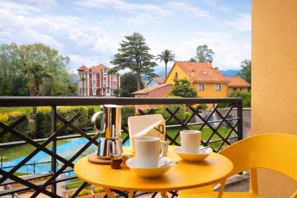 a table with two cups on a balcony with a view at El Rincon de las Americas in Colombres