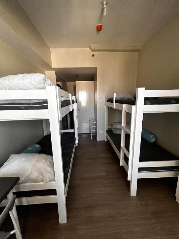 a room with three bunk beds in a room at Orwell Heights-Vista Recto in Manila