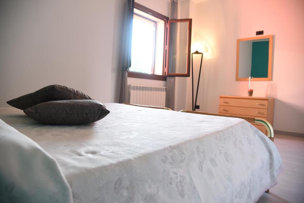 sypialnia z białym łóżkiem z 2 poduszkami w obiekcie Green House w mieście Cavallino
