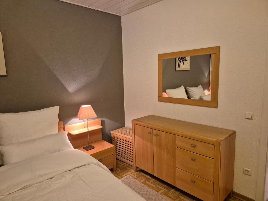 a bedroom with a bed and a dresser with a mirror at Komfortable 3-Zimmer- Wohnung in Ratingen