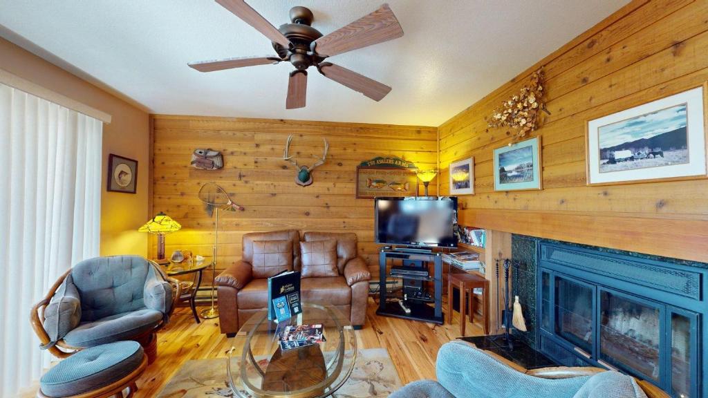 a living room with a fireplace and a ceiling fan at Bluff Condo 4015 in Sun Valley