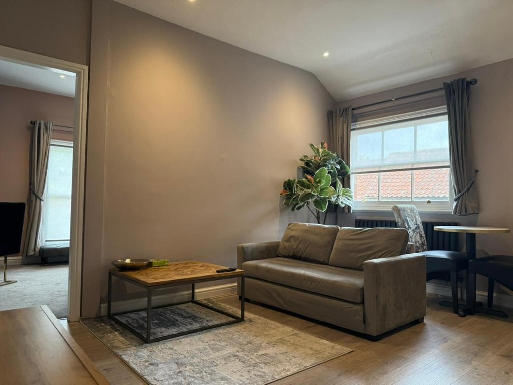 a living room with a couch and a table at The Applewood Regency in Southwell