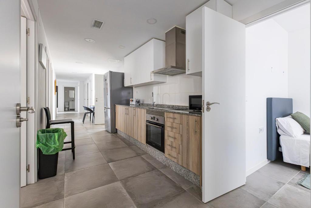 an open kitchen with white cabinets and a table at Coliving San Esteban in La Ñora