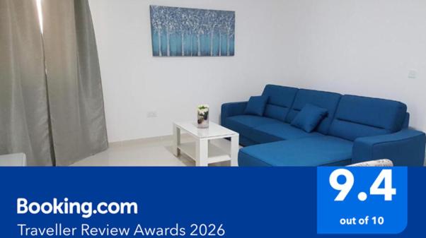 a blue couch in a living room with a table at The Carobs in Marsaskala