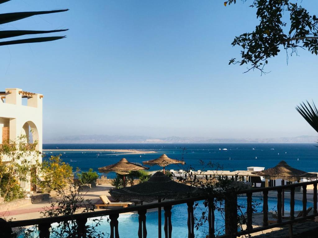 a view of a beach with umbrellas and the ocean at Poolfront Sea View Chalet Top Rated In Dahab in Dahab