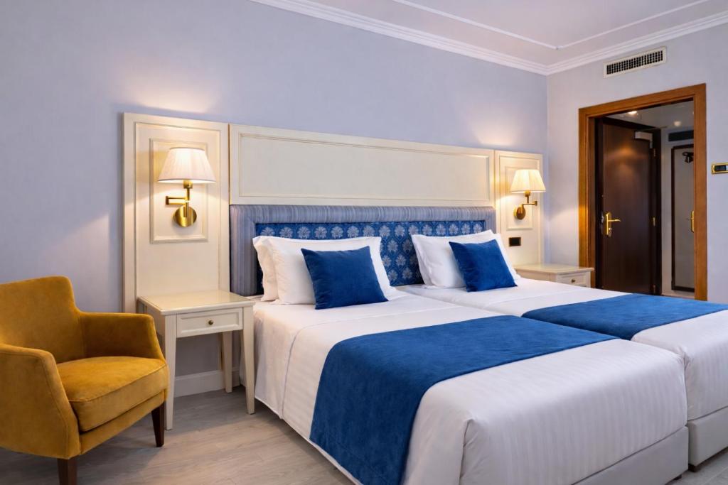 a bedroom with a blue and white bed and a chair at Hotel President Venezia in Mestre