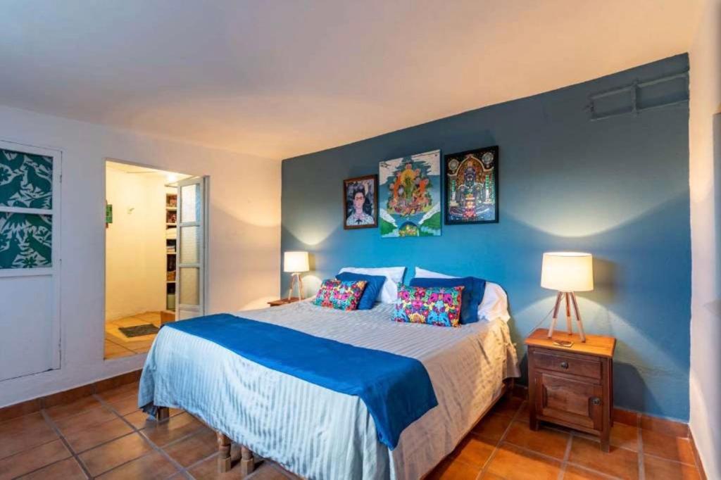 a bedroom with a bed with a blue wall at Business in-suite with office in San Miguel de Allende