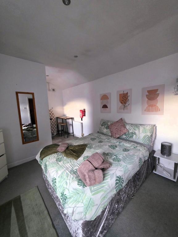 a bedroom with a large bed with towels on it at Sleepy Snug in Swansea