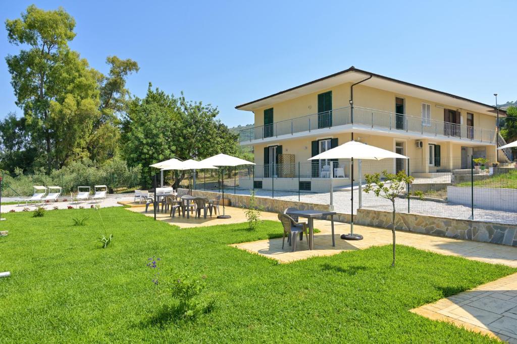 a building with tables and umbrellas in a yard at Villa Melina Bed & Breakfast in Agropoli