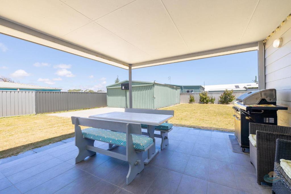 ein Tisch und eine Bank auf einer Terrasse mit Grill in der Unterkunft Seagulls in Lancelin