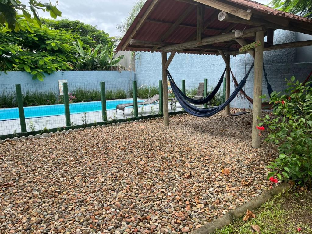 a playground with a hammock and a swimming pool at Residencial Lumar in Itapoa