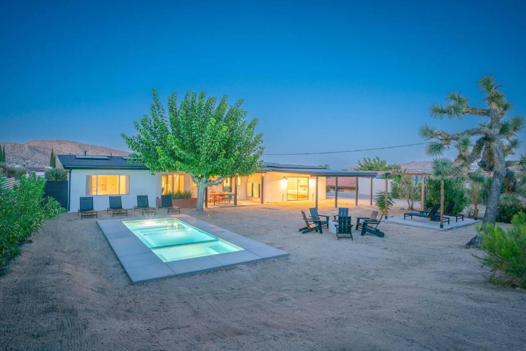 a house with a swimming pool in the desert at Joshua Tree Mid Mod - Pool - Spa - Sauna - Fire pit in Yucca Valley
