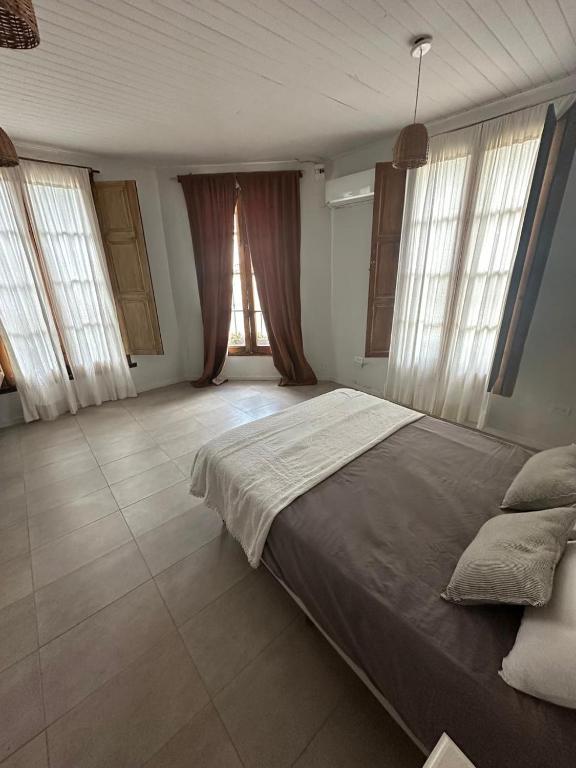 a bedroom with a large bed and two windows at Exclusivo Apartamento Centro Laguna in Chascomús