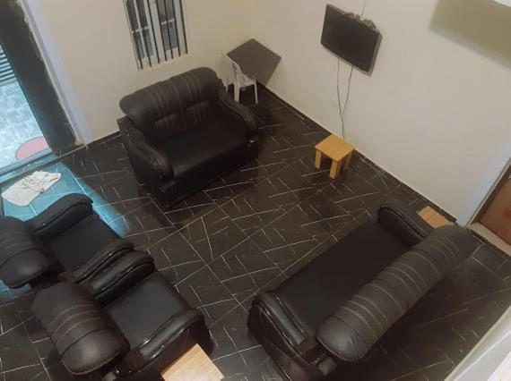 a living room with a leather couch and chairs at Crown Dove in Benin City