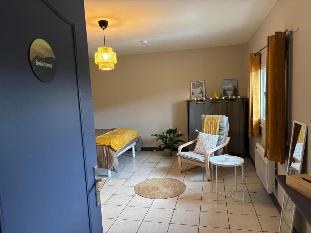 a room with a bed and a table and chairs at Gîtes Ruraux à La Ferme D'Antan in Crolles