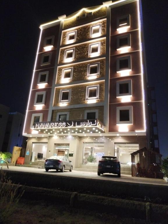 a building with two cars parked in front of it at Nawaress Hotel in Jazan