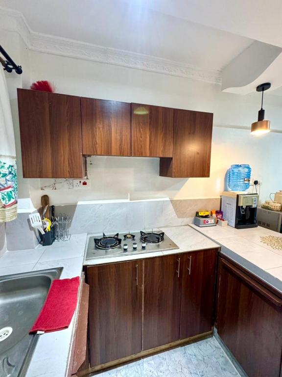 a kitchen with wooden cabinets and a stove top oven at Hideout in Kisumu