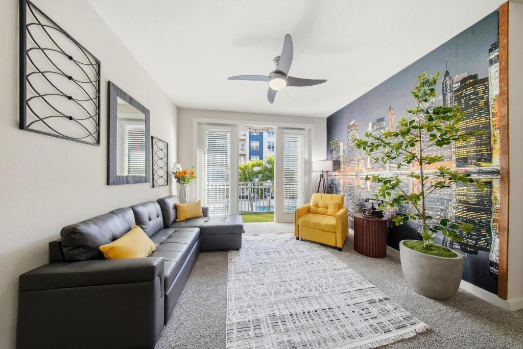 a living room with a black couch and a yellow chair at Stylish 2BR w Balcony, Pool & Pet-Friendly #15 in Tampa