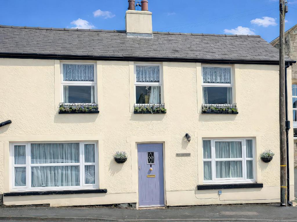 a white house with a purple door and windows at Bronafon in Rhyl