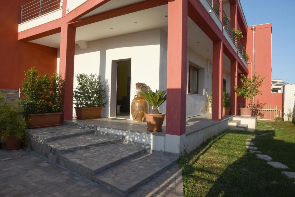 une terrasse couverte d'une maison avec des plantes en pot dans l'établissement Green House, à Cavallino di Lecce