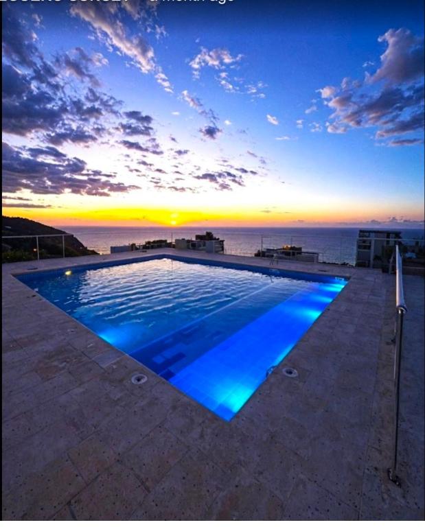 a swimming pool with a sunset in the background at Salguero sunset resort apartmento in Gaira