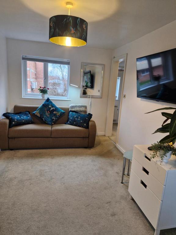 a living room with a couch and a tv at 4 Bancroft place in Stratford-upon-Avon