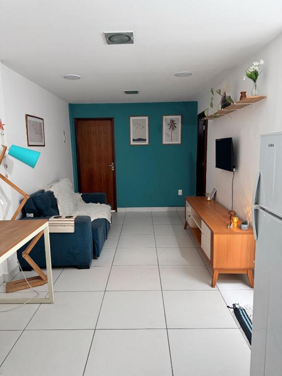 a living room with a bed and a blue wall at Margem do São Francisco 104 praiano in Petrolina