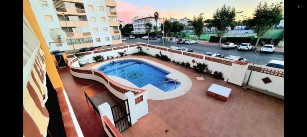 a view of a building with a swimming pool at Loft Claudia Portil in Punta Umbría