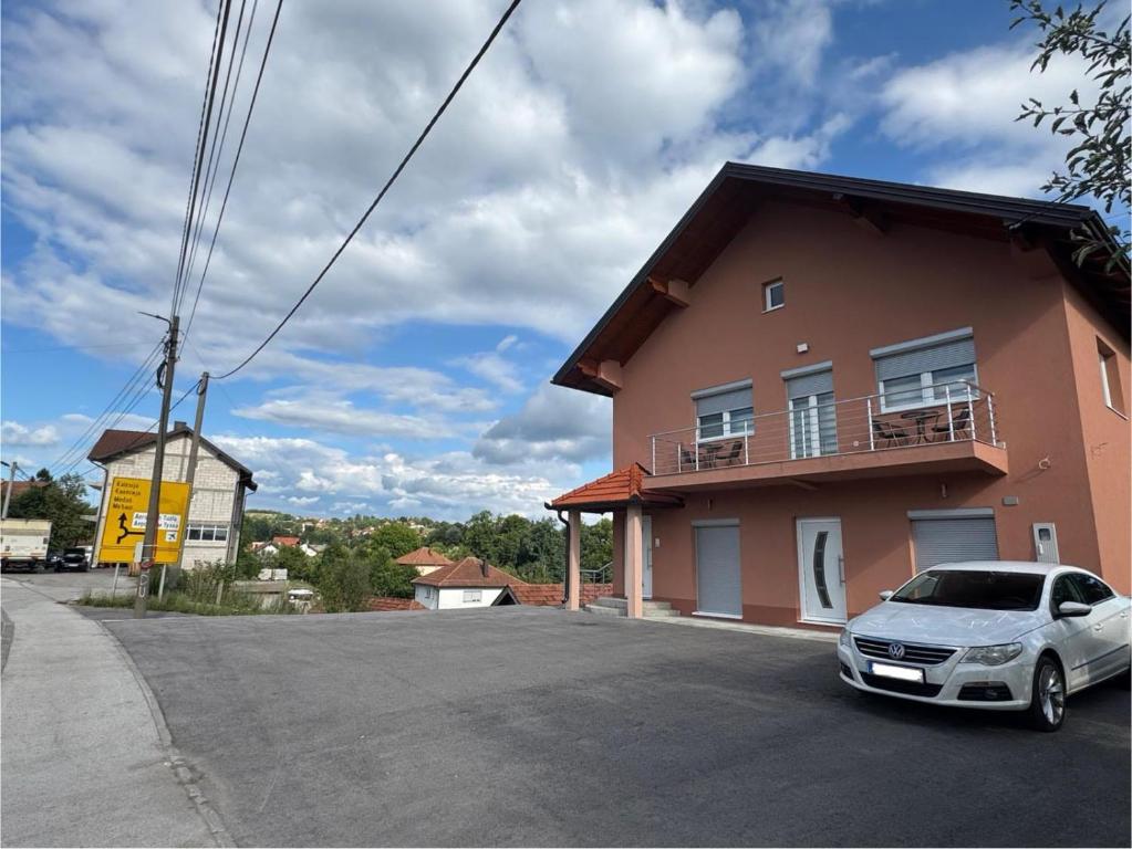 a car parked in a parking lot next to a house at Apartmani Bella in Krževići