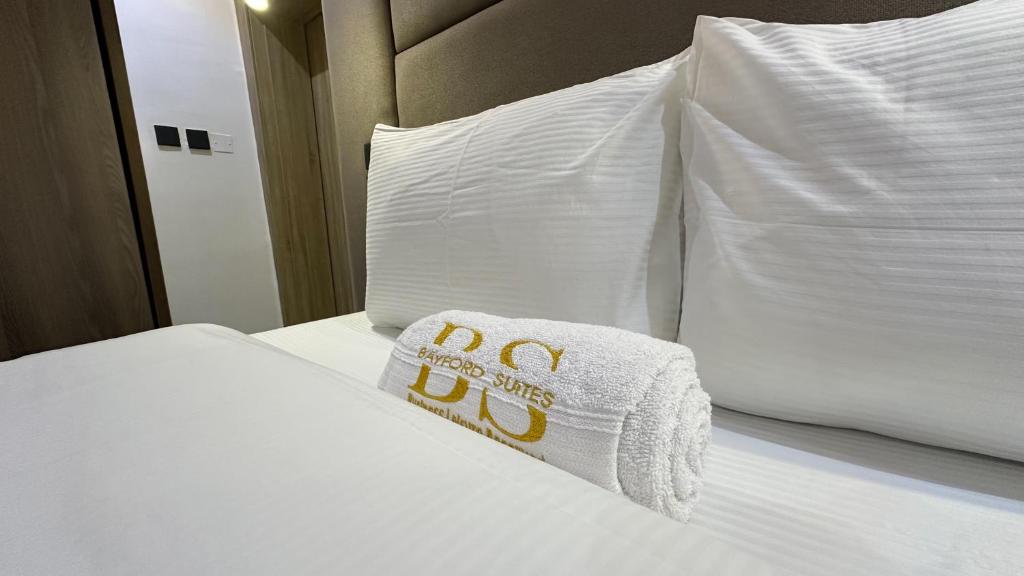 a white bed with a napkin on top of it at Bayford Suites in Abuja