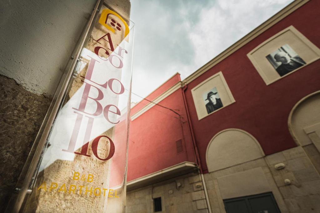a building with a sign on the side of it at B&B Arcolobello ApartHotel in Corato