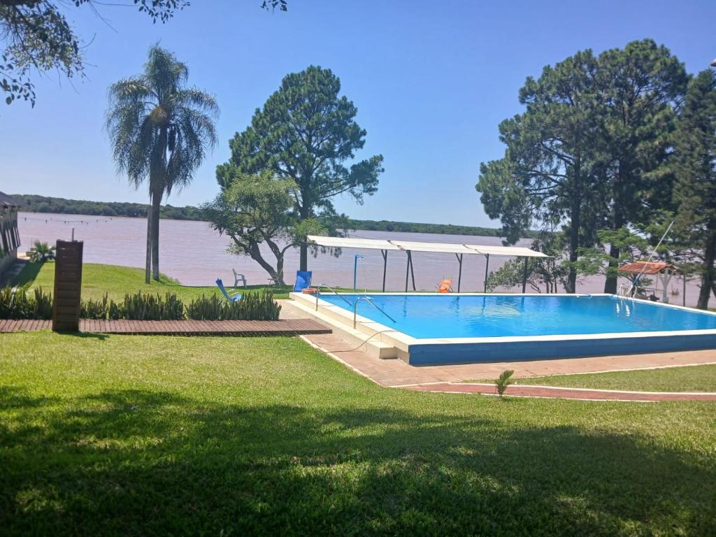 a large swimming pool next to a body of water at Paraiso Yapeyù in Yapeyú