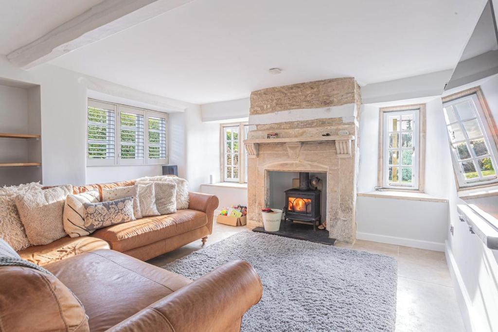a living room with a couch and a fireplace at Washmere House in Colerne