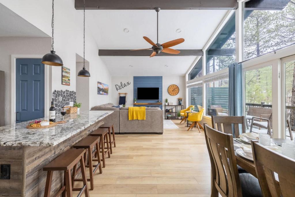 an open kitchen with a bar and chairs at Pine Cone Cabin Flagstaff 3BR 2BA in Flagstaff