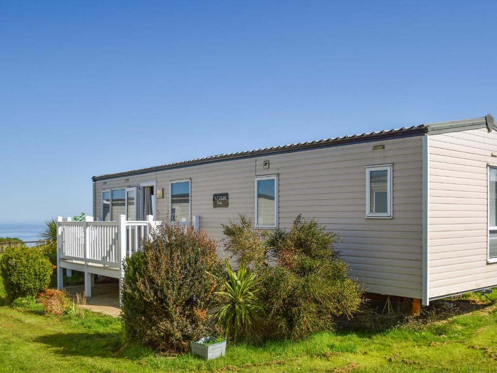 a mobile home with a porch and a deck at Sea View in Trimingham