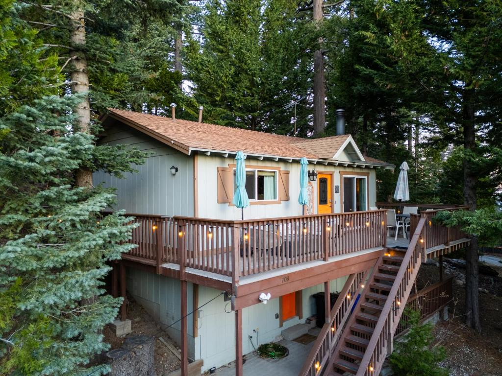 a house with a deck in the woods at Peaceful Mountain Sanctuary near Arrowhead Village in Lake Arrowhead