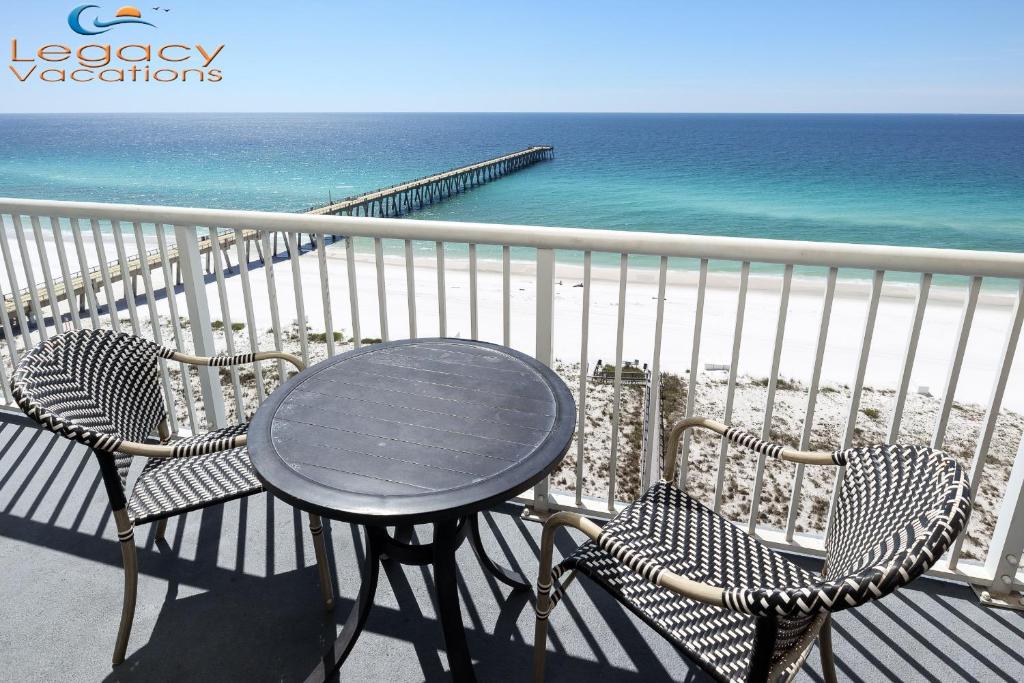 a table and chairs on a balcony overlooking the ocean at Summerwind 1202C in Navarre