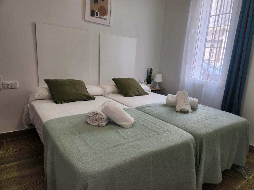 two beds in a bedroom with towels on them at Pinedo Playa Holiday in Valencia