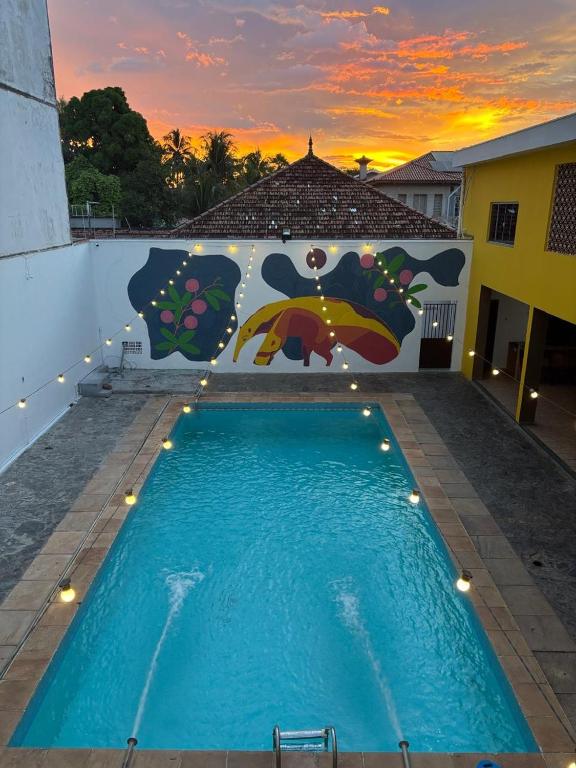 a pool with a painting on the side of a building at Dom Alberto Hostel in Corumbá