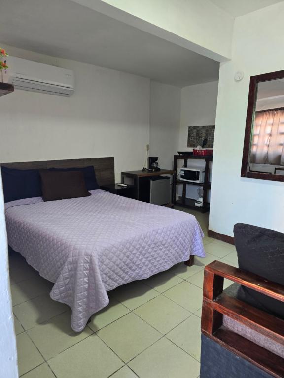 a bedroom with a bed with a purple blanket at Habitación 2 climatizada cerca de IMSS UMAE in Veracruz