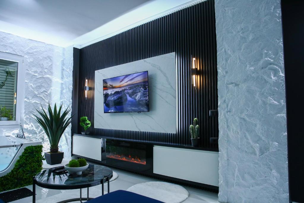a living room with a fireplace and a table at Amiri Lux Suites in Shkodër