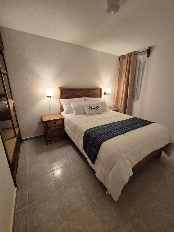 a bedroom with a large bed with two lamps and a staircase at Casa Luna TX in Tequisquiapan