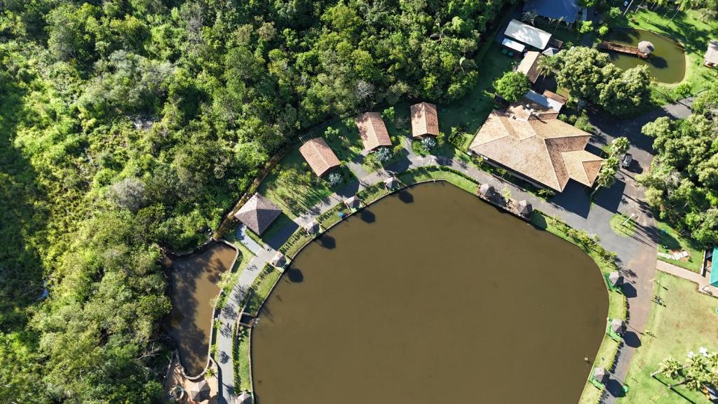 an overhead view of a lake and a house at Chalé dos Lagos Ecoresort in Mandaguaçu