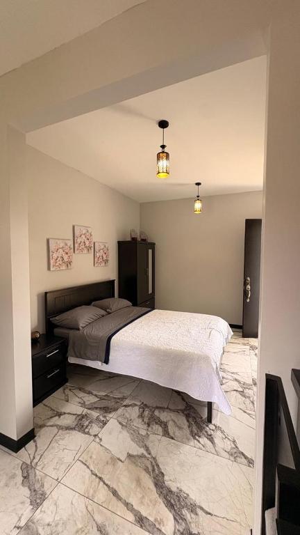 a bedroom with a large bed and a marble floor at Apartamento Decrusi in Alajuela